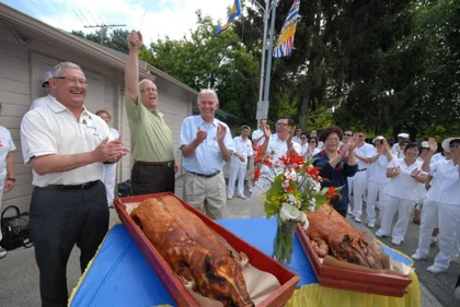 Members and guests celebrate the 2010 artificial-turf opening with a roast-pork cutting ceremony